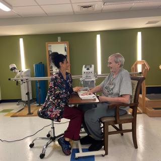 A therapist and an elderly patient engage in a rehabilitation session.