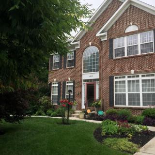 A brick house with a well-maintained lawn and garden.