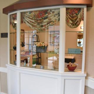 An interior view of a reception area with a window display featuring decorative items.