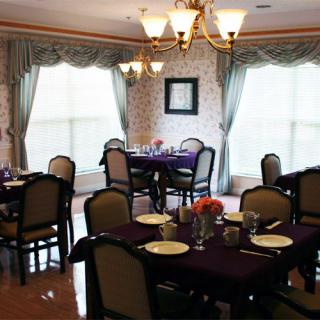 A cozy dining room with elegantly set tables and a chandelier.