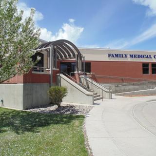 Exterior view of a family medical clinic building under a clear blue sky.