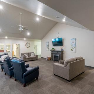 A modern living room with comfortable sofas and a fireplace, featuring a television on the wall and elegant decor.