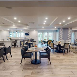 A modern and spacious restaurant interior with neatly arranged tables and chairs.