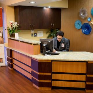 A receptionist working at the front desk of a modern office.
