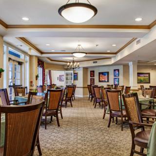 A well-lit dining area with arranged tables and chairs, featuring elegant interior design.