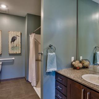 A modern bathroom featuring a sink, mirror, and shower area with elegant decor.