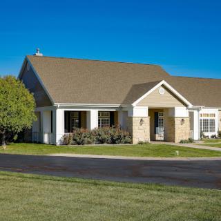 A charming suburban home with a well-maintained lawn and clear blue skies.
