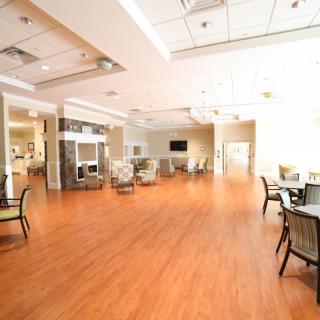 A spacious and modern lobby area with wooden flooring and comfortable seating.