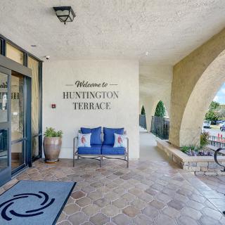 The entrance to Huntington Terrace features a welcoming sign, a comfortable bench, and decorative plants.