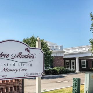 Entrance of an assisted living and memory care facility with a sign out front.