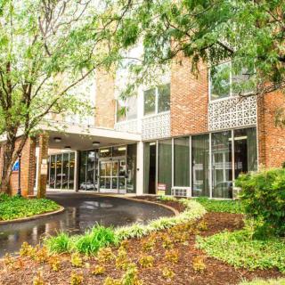 An inviting building entrance surrounded by lush greenery and landscaping.