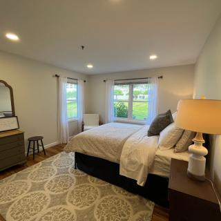 A modern bedroom with a cozy bed, stylish decor, and warm lighting.