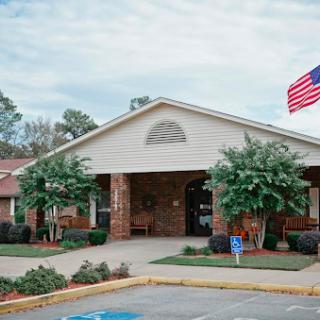 A welcoming community center featuring well-maintained landscaping and an American flag.