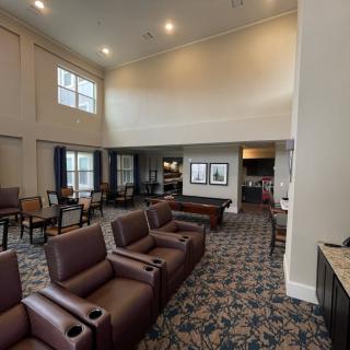 A spacious lounge area with comfortable seating and large windows.