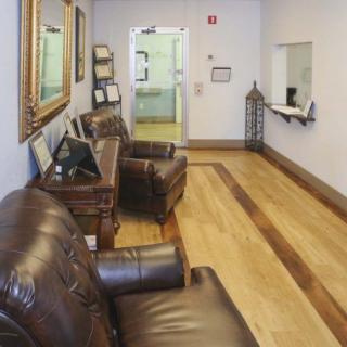 A cozy waiting room with leather chairs and framed artwork.
