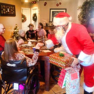 A festive family gathering with Santa Claus delivering gifts during a holiday celebration.