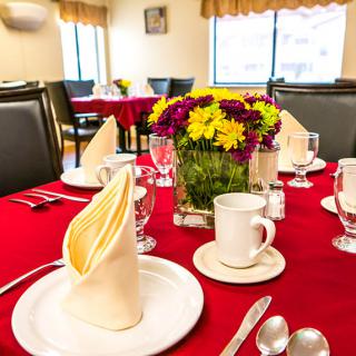 A beautifully set dining table with flowers and elegant tableware in a restaurant setting.