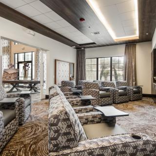 A modern lounge with patterned seating and large windows.