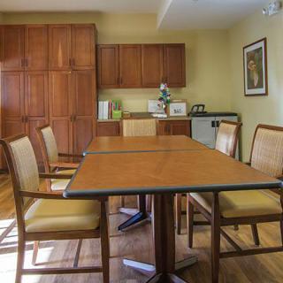 A cozy meeting room with a wooden conference table and chairs, set in an elegant office interior.