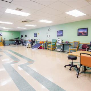 A spacious rehabilitation and physical therapy clinic with exercise equipment and seating.