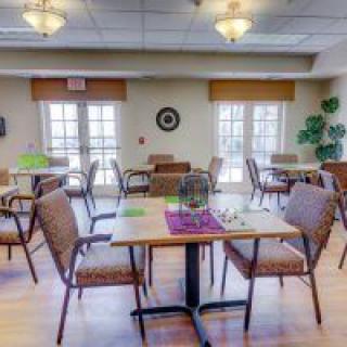 A well-lit dining area with neatly arranged tables and chairs, suitable for a restaurant or cafeteria setting.