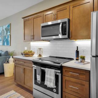 A modern kitchen with stainless steel appliances and wood cabinets.