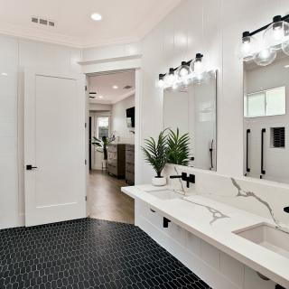 A modern bathroom with sleek fixtures, a large mirror, and minimalist decor.