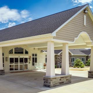 A welcoming entrance to a modern commercial building under a bright blue sky.