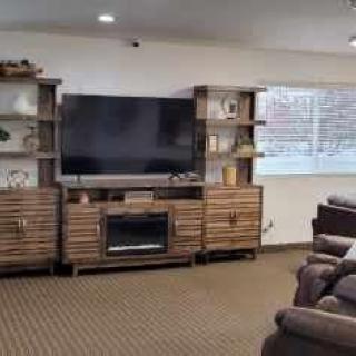 A cozy living room featuring a large entertainment center with a television and shelves.