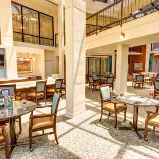 A bright and inviting dining area with elegant tables and chairs, illuminated by natural light.