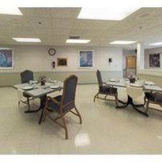 An empty dining room with tables and chairs arranged neatly.