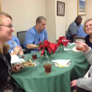 A group of people enjoying food and drinks around a decorated table indoors.