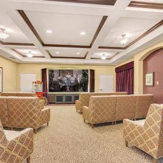 A cozy theater room with patterned seating and a large projector screen.