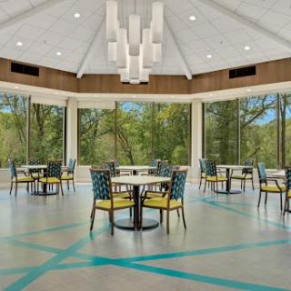 A bright and modern dining area featuring large windows that offer a view of the surrounding nature.