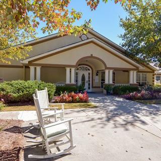 A charming house with a welcoming entrance and a rocking chair on the front patio.