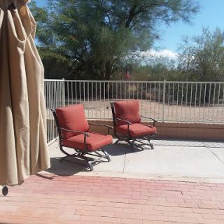 A serene outdoor space featuring two comfortable chairs on a sunny patio.