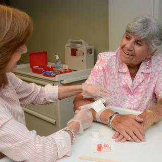 A nurse is attending to an elderly patient during a medical examination.