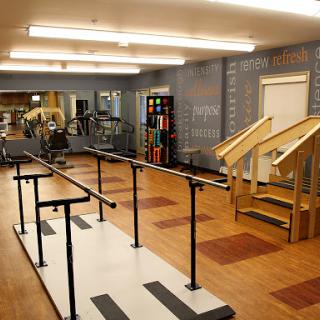 A physical therapy room equipped with parallel bars and stairs for rehabilitation exercises.