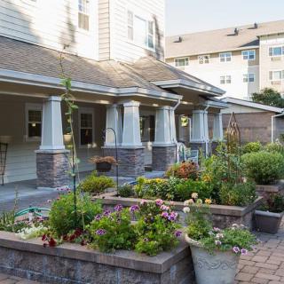 A well-maintained garden with vibrant flowers in front of a residential building.