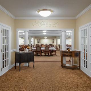 Elegant dining area with multiple tables and chairs, featuring warm lighting.