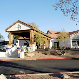 A well-designed building with a welcoming entrance set against a clear blue sky.