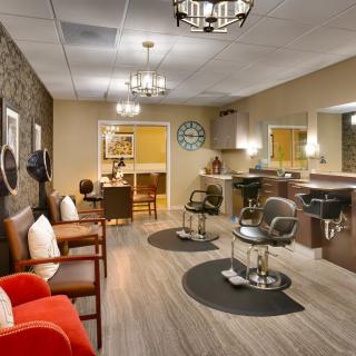A modern salon interior with styling chairs, mirrors, and a waiting area.