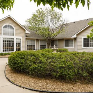 A well-maintained house with a lush garden and curved pathway.