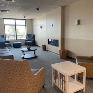 A cozy lounge area with comfortable seating and a large window.