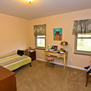 A vintage bedroom with a bed, desk, and decor.