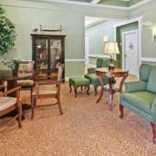 A classic living room with green walls and comfortable seating.
