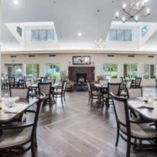 A spacious and modern dining area with elegant furnishings and large windows.