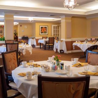 An elegantly decorated dining room with several tables set for meals.