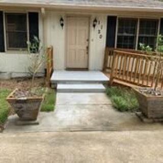 Front entrance of a house with an accessible ramp and planters.