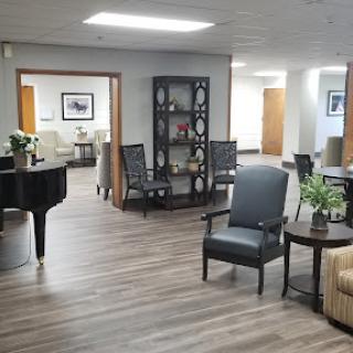 A spacious and modern lobby featuring comfortable seating, a piano, and elegant decor.